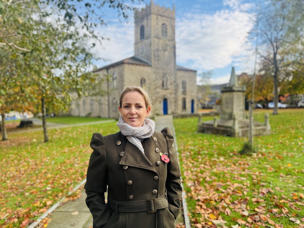 Person wearing a poppy with church in background